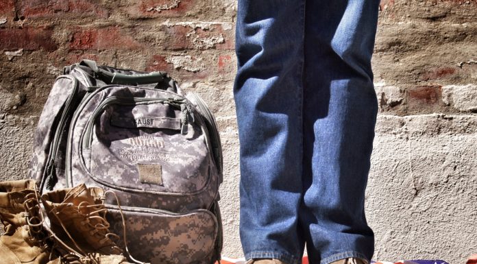 man's legs standing next to military gear